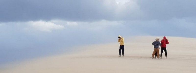 Quatre personnes, nuages sur sable